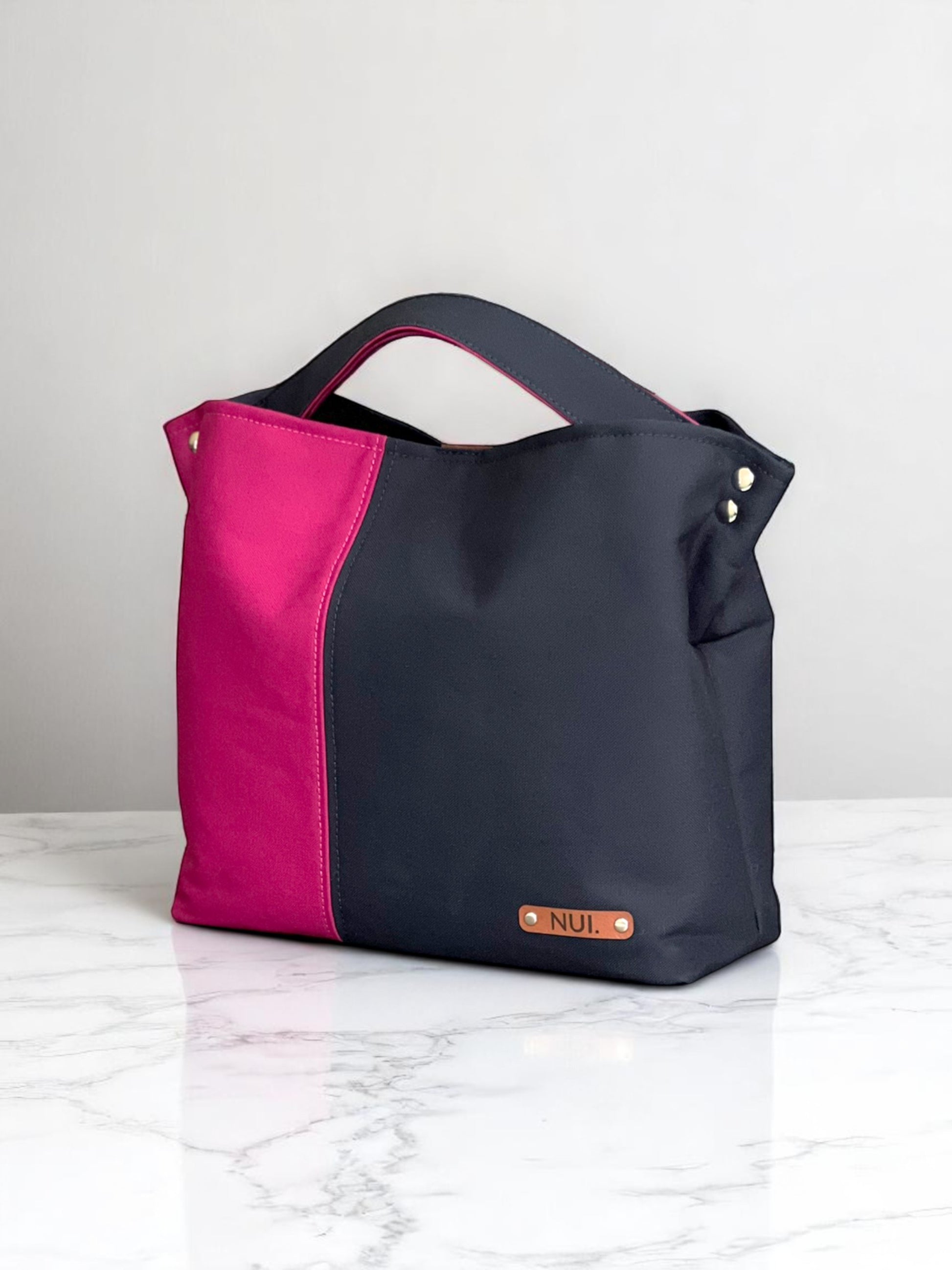 NUIdesign tote bag in Midnight and Fuchsia Rose canvas, showing bold two-tone colour and structured style.