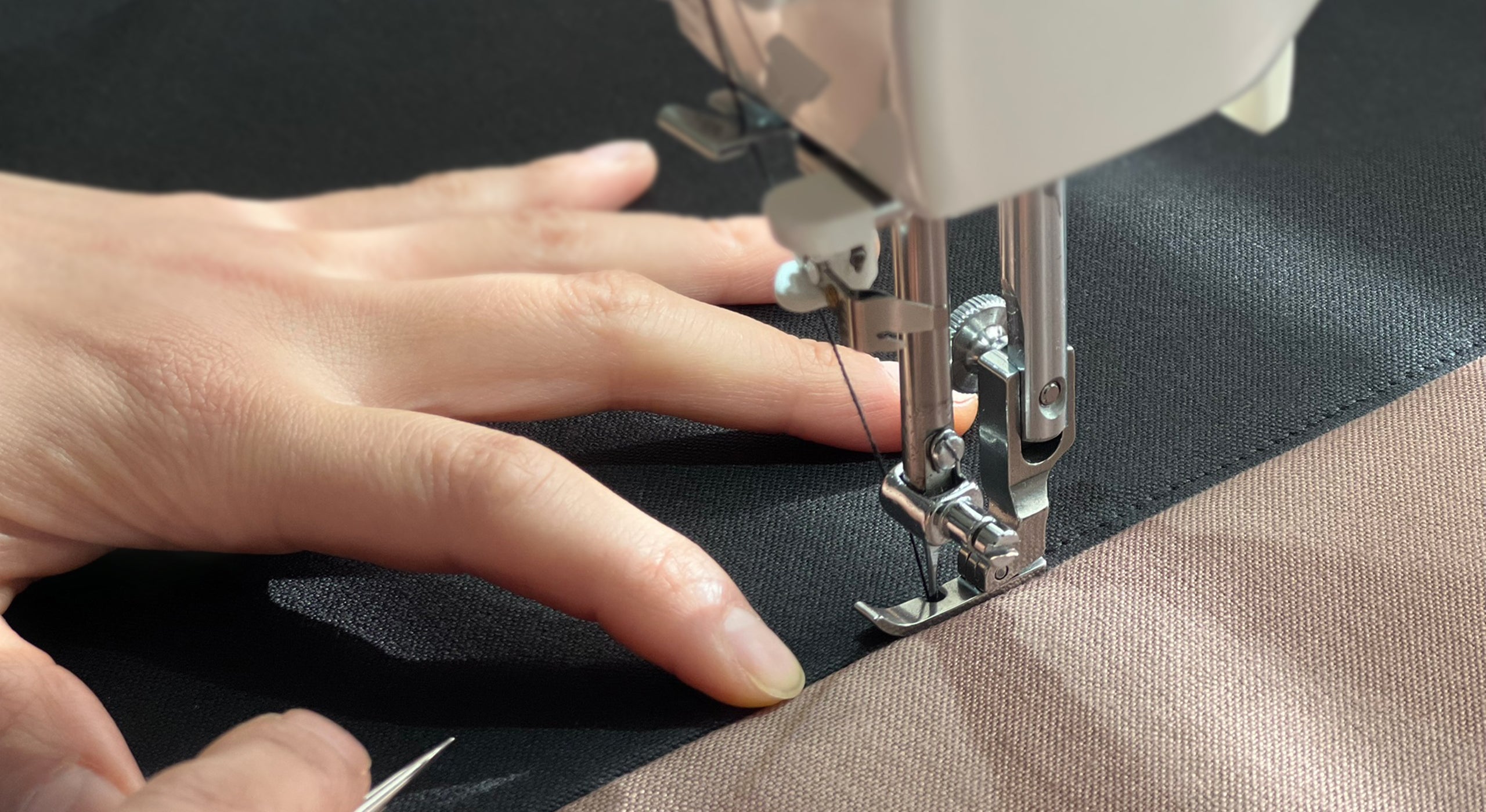 Close-up of hands sewing Japanese cotton canvas on a machine, representing NUIdesign’s handmade bags crafted in Melbourne.