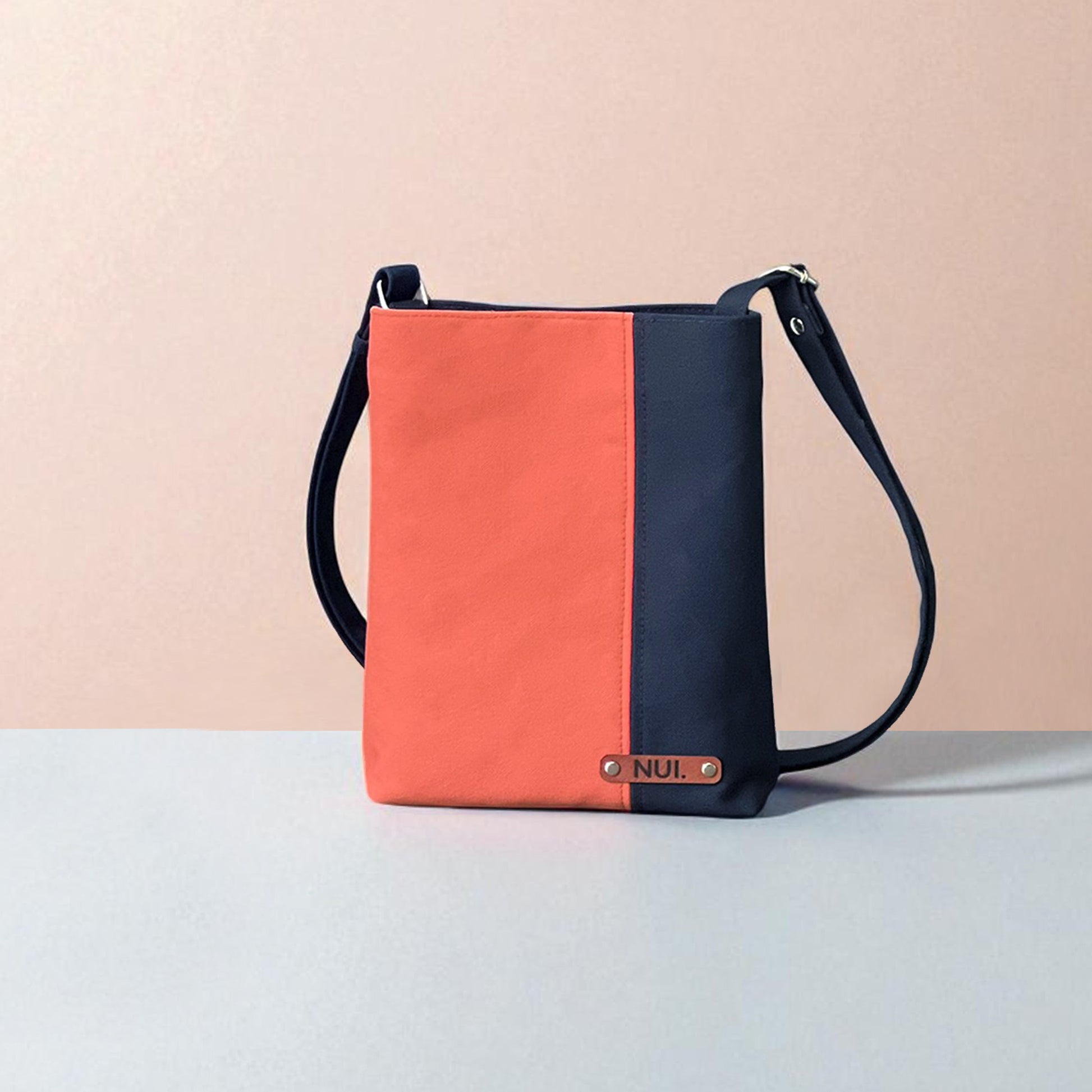 Deep navy base with a fresh coral  pane. Two-tone crossbody bag with adjustable strap, handmade by NUIdesign in Melbourne.