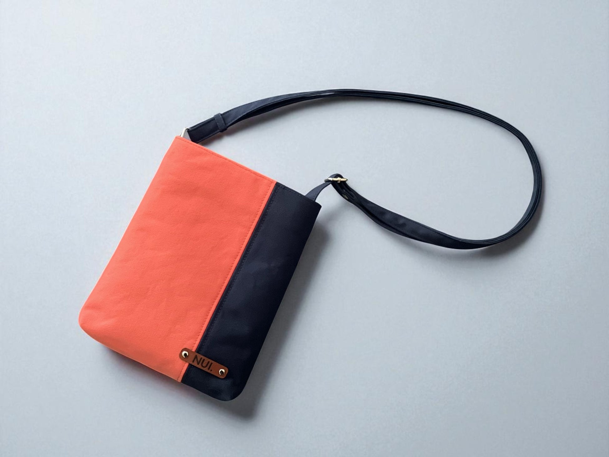 Top-view of Cotton Canvas Crossbody Bag with a deep navy base with a fresh coral panel by NUIdesign.