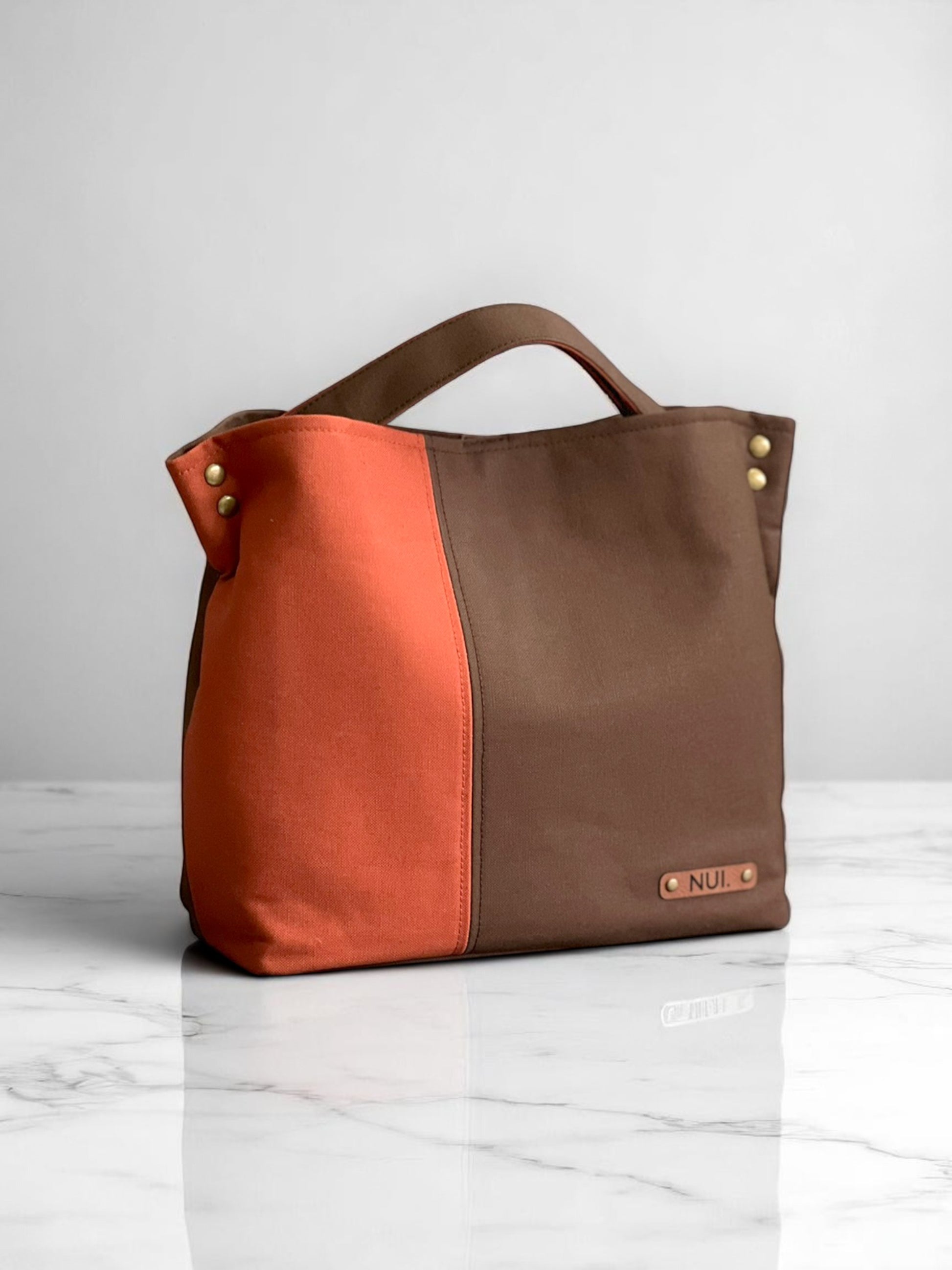 Handmade NUIdesign tote bag in Brown and Terracotta canvas, showing two-tone design and structured form.