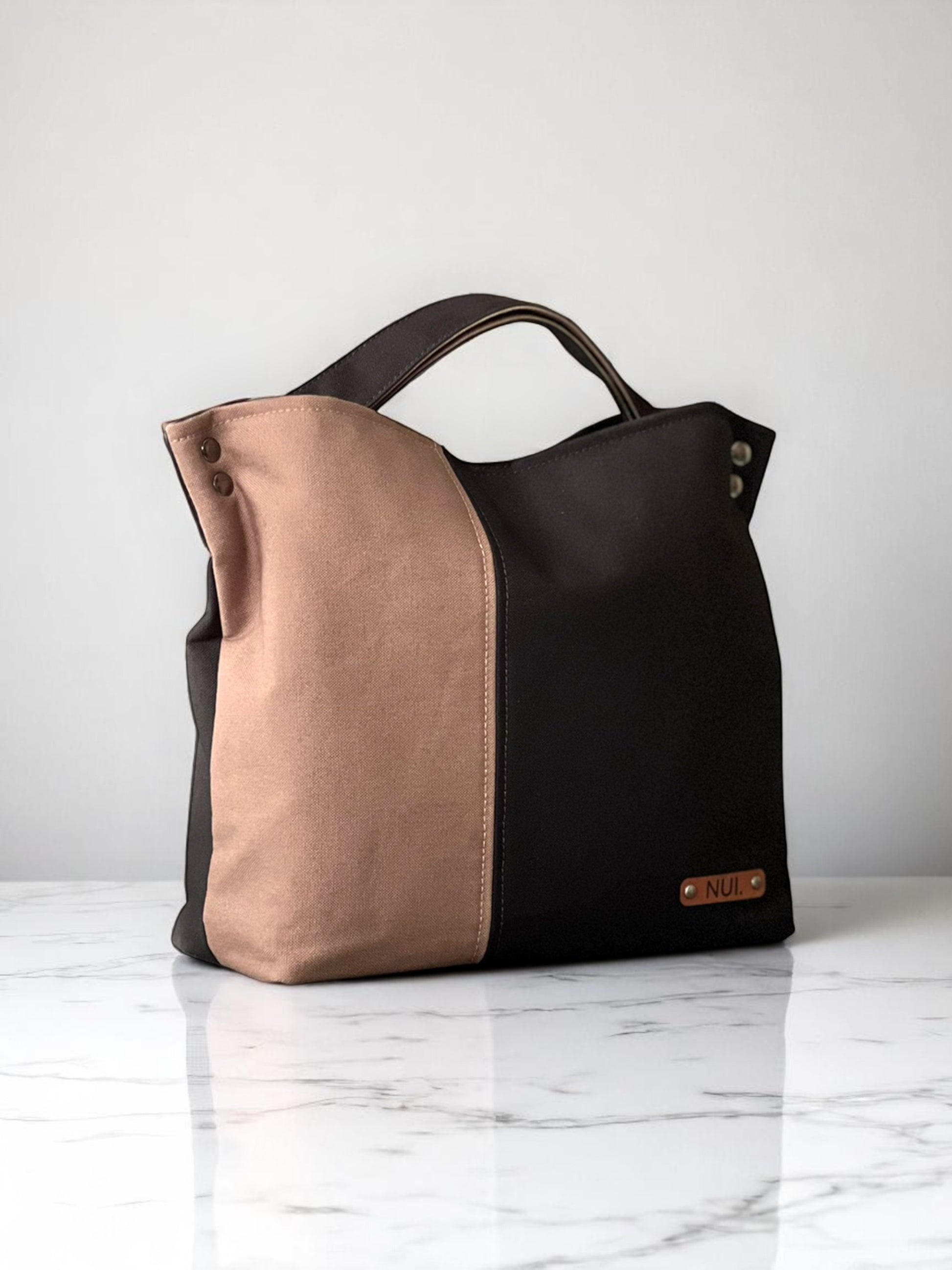 Handmade NUIdesign tote bag in Black and Wild Mushroom canvas, showing two-tone design and structured shape.