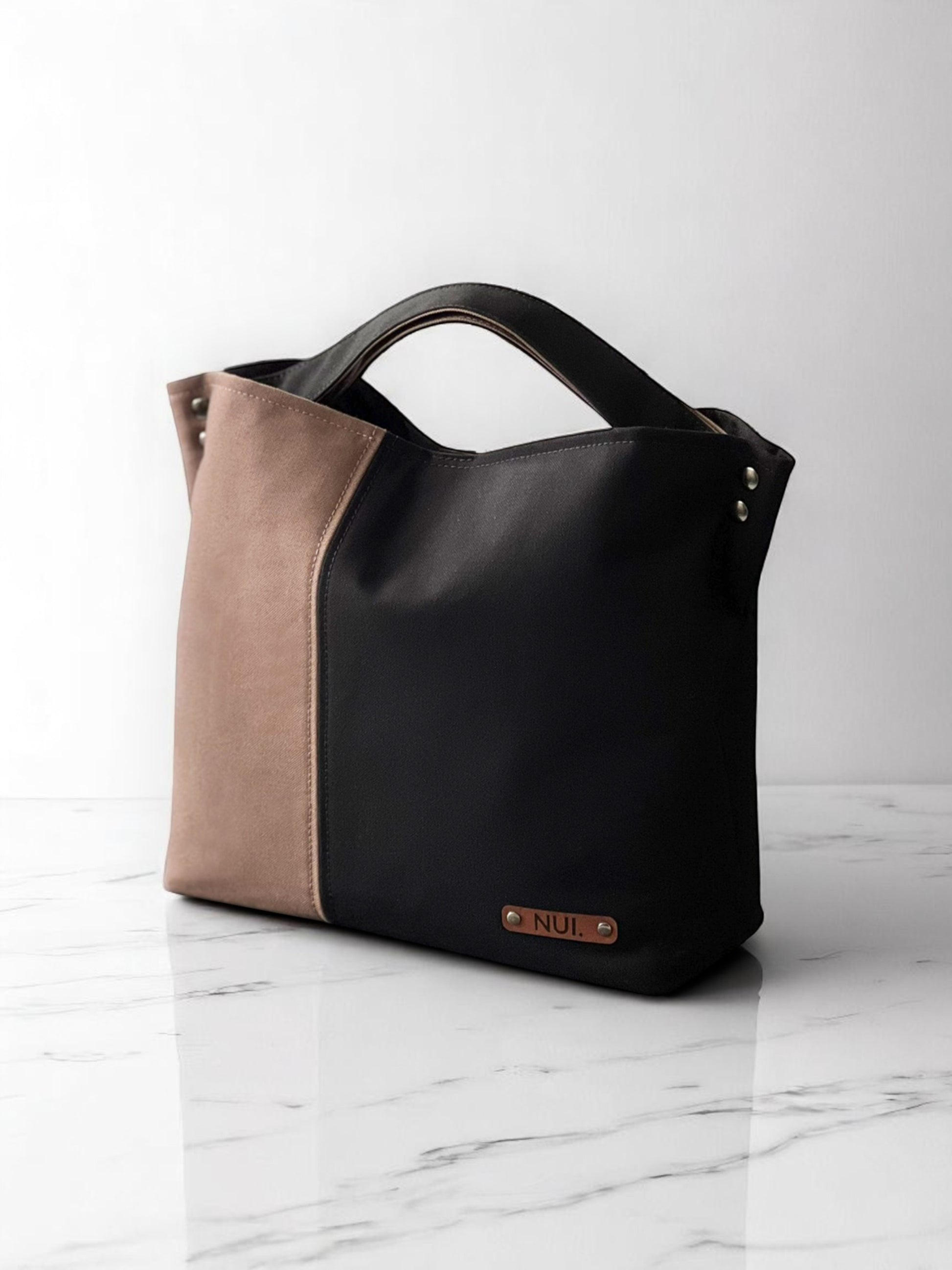 Handmade NUIdesign tote bag in Black and Wild Mushroom canvas, showing two-tone design and structured shape.