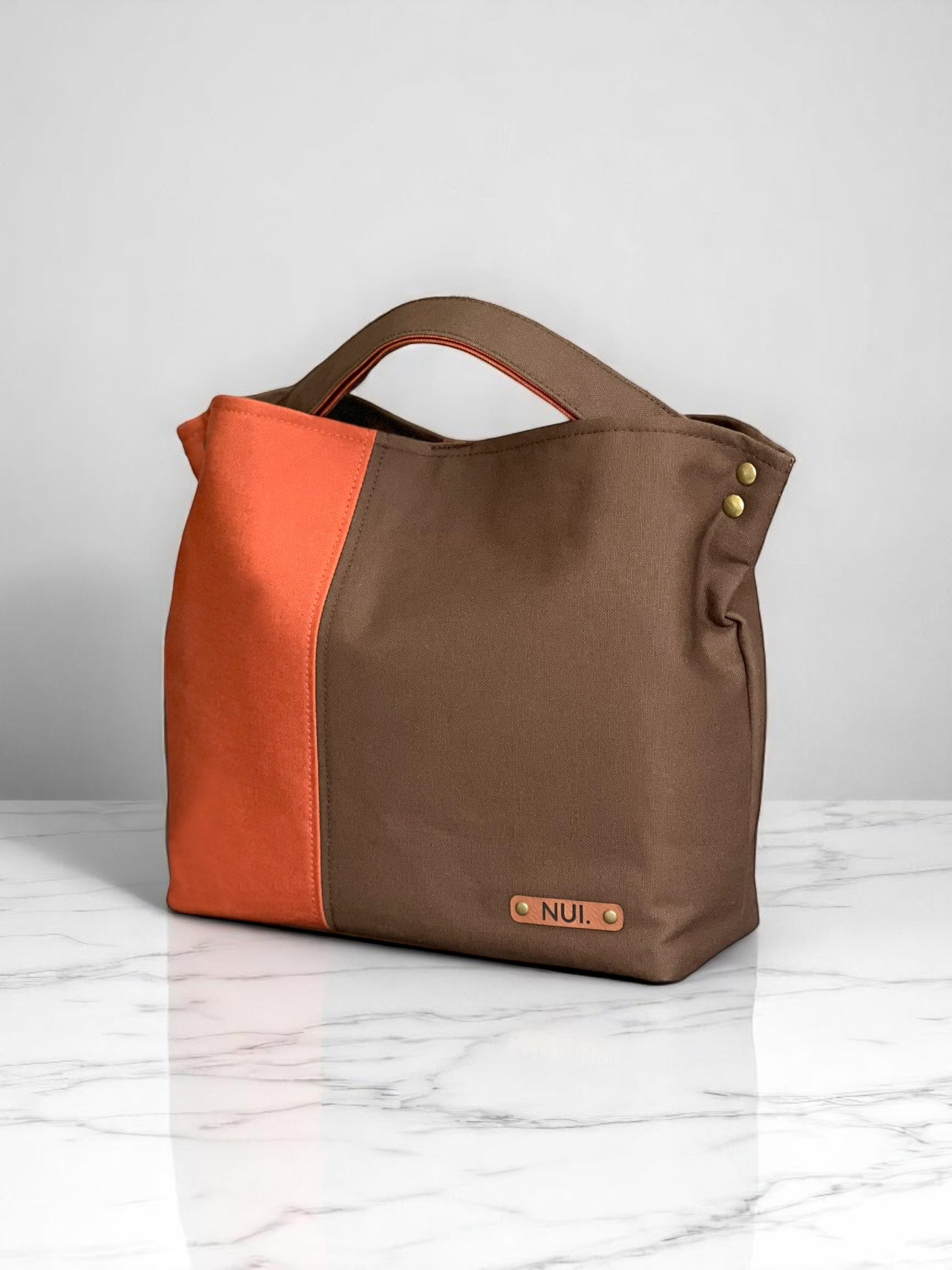 Handmade NUIdesign tote bag in Brown and Terracotta canvas, showing two-tone design and structured form.